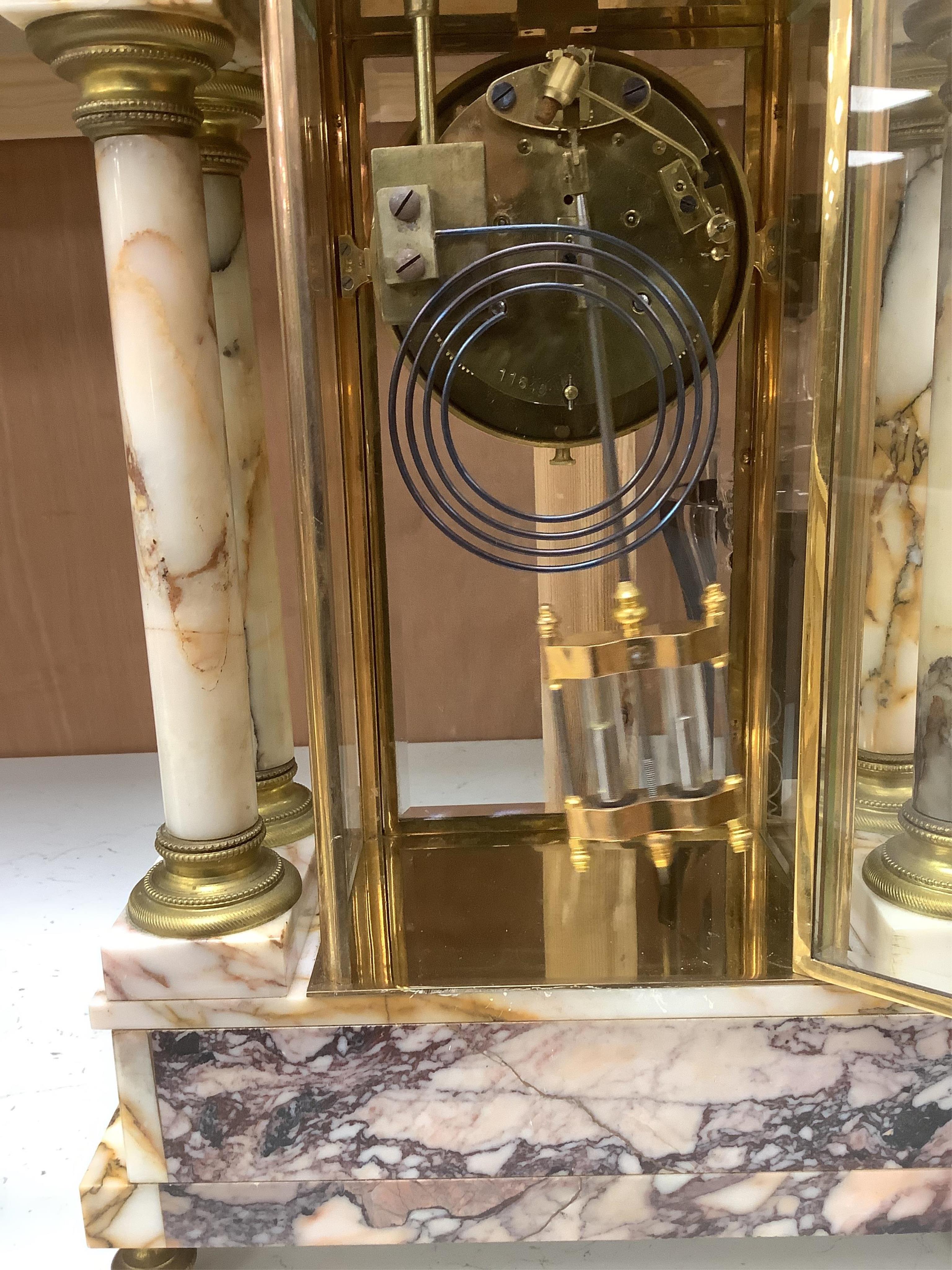 A French marble and gilt bronze four glass portico clock, striking on a coiled gong, 54cm high. Condition - fair to good.